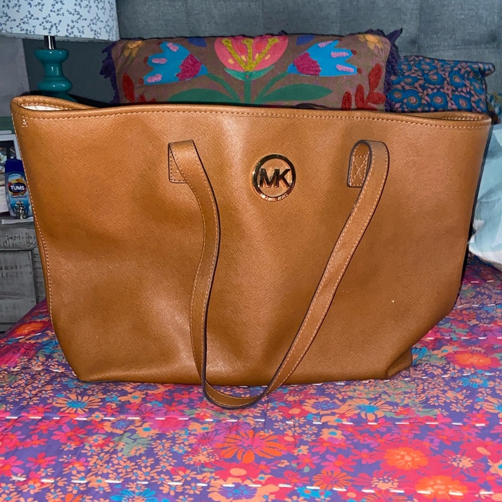 Michael Kors tote. She’s in mint condition. Third photo is the bottom of the bag
